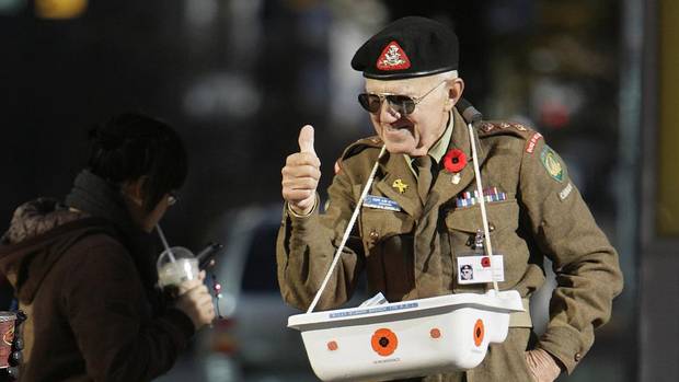 Arthur Hughes from the Billy Bishop Legion or Royal Canadian Legion 176 gives the thumbs up to those wearing a poppy while he sells poppies in downtown Vancouver, BC, November 5, 2007.