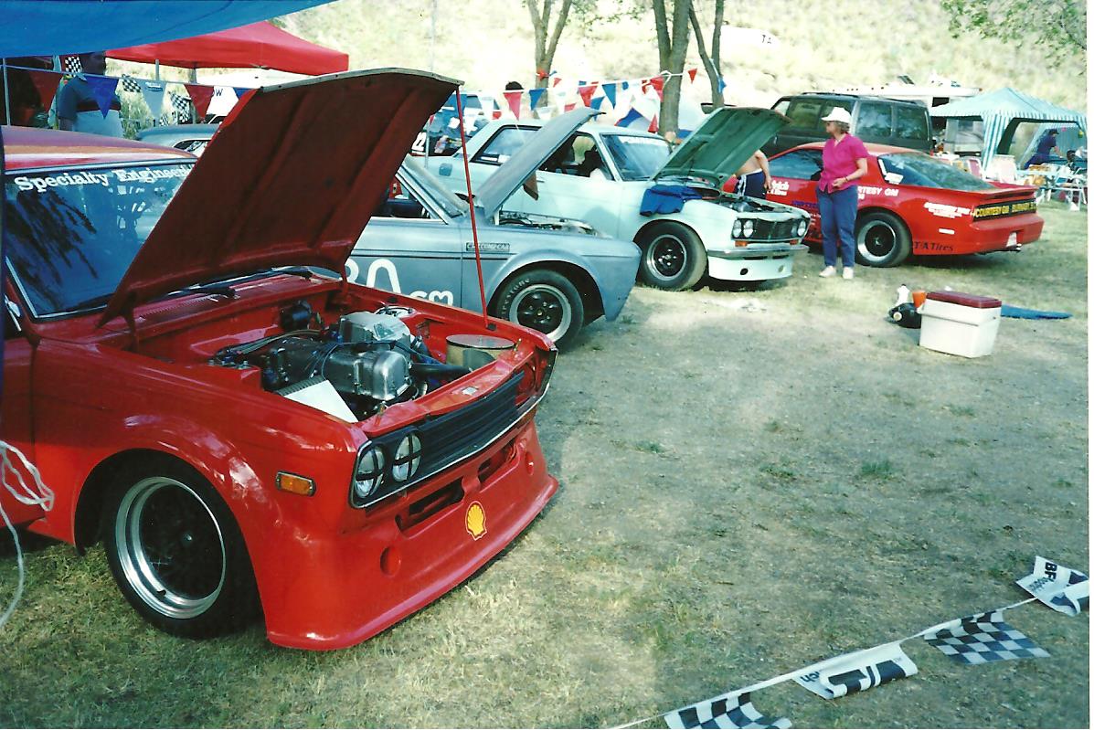 who (L to R): Keith's car, Dave's car, Brent's car, Campbel Carlyle's Firebird, with Carolyn Koehn standing in front of it?<br />where: Knox Mountain, Kelowna BC, 199?